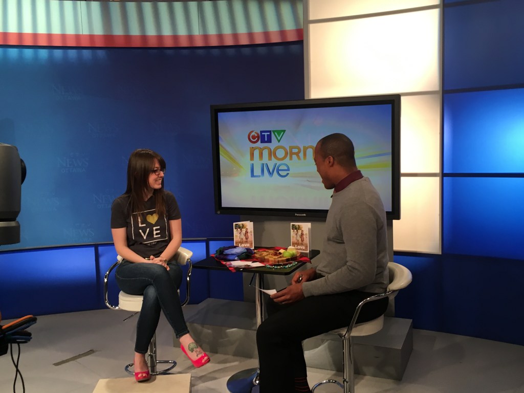 Jenn Is sitting on the set of CTV Morning Live with one of their hosts.