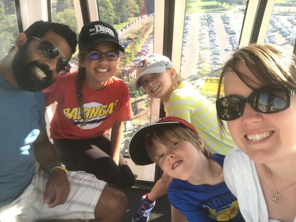 Jenn, her partner, and three children are smiling for a photo.